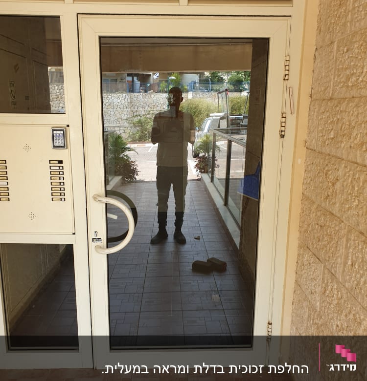 דלת זכוכית עם השתקפות אדם